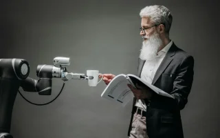 A scientist being handed a coffee by a robotic arm.